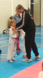 Veronique krijgt de medaille voor de 2de plaats kata omgehangen door Wim sensei van Tadashii-do.